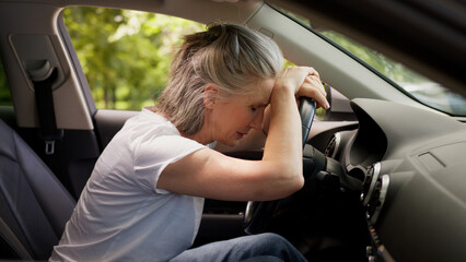 Caucasian mature elderly woman senior lady female automobile taxi driver pensioner inside auto...