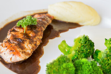 Grilled salmon steak with herbs mashed potatoes and vegetables