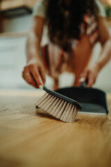 Young caucasian woman cleaning the house while listening to music