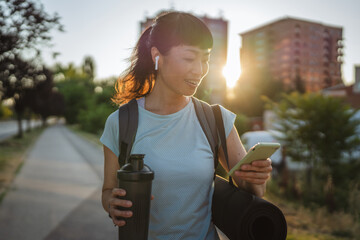japanese woman drink protein shake and use mobile phone go to training