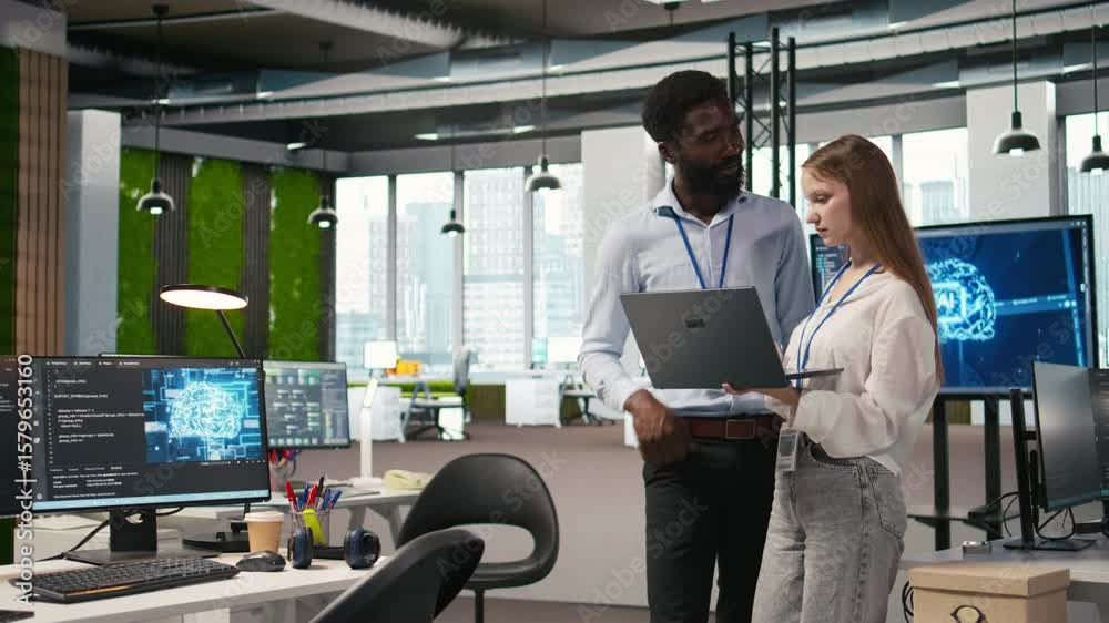 Poster junior dev and colleague in office reviewing ai system metrics, monitoring performance dashboards. t