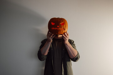 Dark spooky copy space banner with man with jack-o-lantern unstead of head. Low key