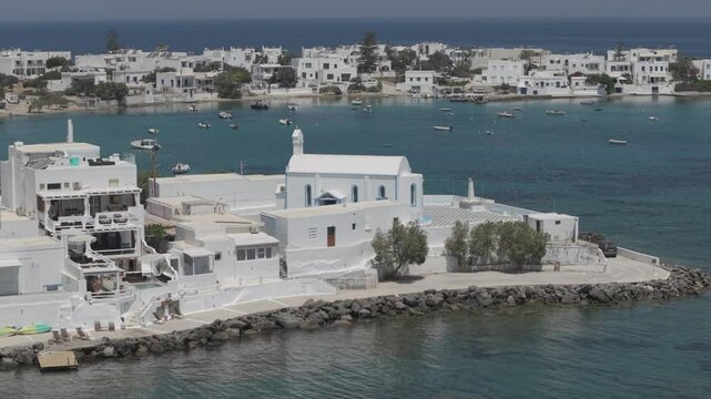 Zoom aerial video of a white church in Pollonia, Milos, Greece. 3x telephoto lens. D-Log M profile. professional video