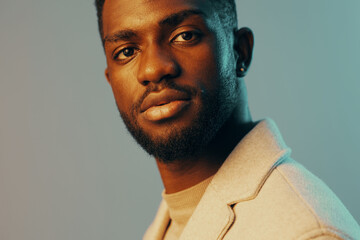 Stylish young Black man with a thoughtful expression in a modern setting, highlighting emotion and...