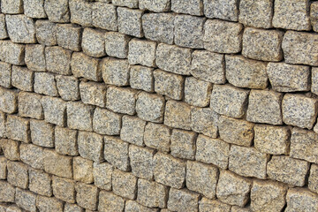 Close-up view of weathered stone brick wall texture showing natural aging and architectural detail