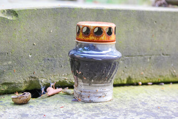 Decorative ceramic vase with traditional pattern design placed on stone surface in outdoor garden...