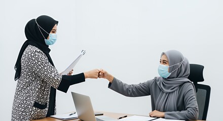 Masked Muslim Businesswomen Fist Bumping in Office
