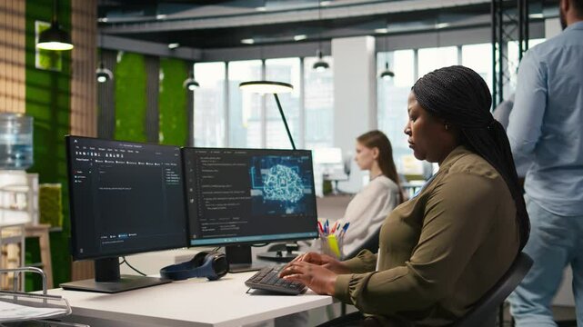Jolly female programmer at office desk pleased after developing application using machine learning automation. Joyous employee satisfied after debugging applications using neural networks, camera A