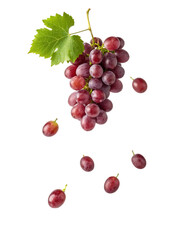 Obraz premium Bunch of fresh red grapes with a green leaf against a dark background presents natural fruit food.