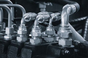 group of metal tubes are connected to each other as part of a high-pressure hydraulic machine blue...