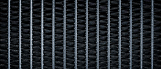 Close-up of a black and silver metallic object with many fine lines. object is a radiator as a...