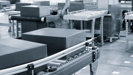 Cardboard boxes on conveyor belt of modern distribution logistics center, delivery logistics concept background blue tone