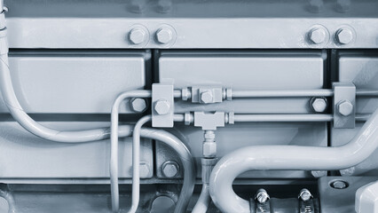 Shown is a large engine with many tubes, bolts and various parts. Auto service concept background