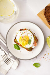 Plate of tasty sandwich with egg on grey background