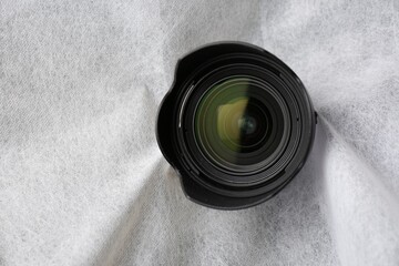 Hidden camera lens through torn hole in white fabric