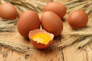 Fresh eggs and spikes on wooden table, closeup