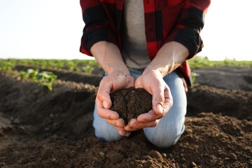 Man holding pile of soil in field, closeup
