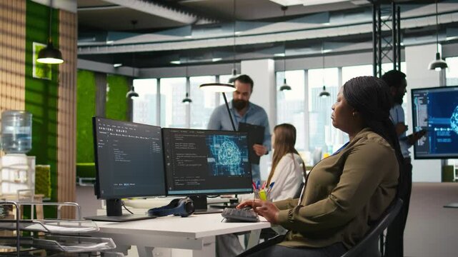 Female admin using AI neural networks tech on computer to optimize performance and forecast issues. Woman in office training artificial intelligence deep learning models using PC, camera A