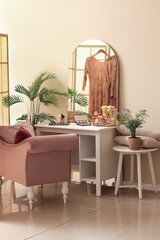 Interior of dressing room with table, makeup products and armchair