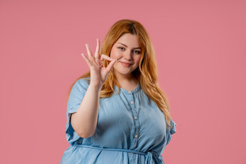 Body positive woman OKAY sign, ok gesture. Happy lady, correct choice, pink wall