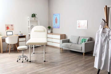 Interior of medical office with couch, sofa and doctor's workplace