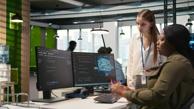 Manager teaching young technician how to develop software and optimize code using AI. Team leader guiding intern in office on how to use artificial intelligence to resolve bottlenecks, camera A