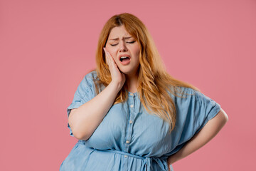 Plus size woman with tooth pain, pink background. Toothache, dental problem