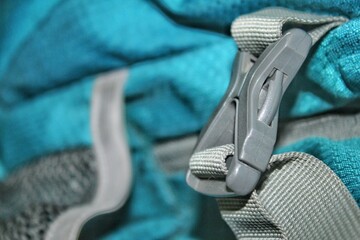 The buckle on a backpack is made of plastic.