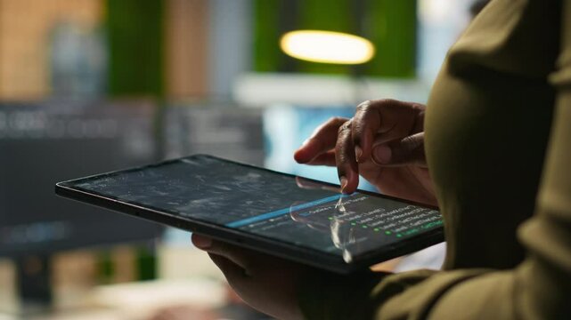 Close up of engineer using tablet to write code, developing machine learning APIs. IT professional troubleshooting software errors and faults using artificial intelligence, camera A