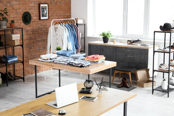 Interior of men's clothing store with shelf units and tables
