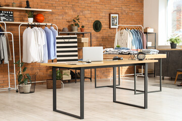 Shopping bag with laptop on table in men's clothing store