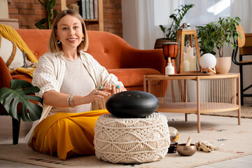 Beautiful woman playing glucophone on carpet at home