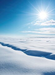 Obraz premium Vast expanse of pristine white snow under a vibrant blue sky, with a bright sun