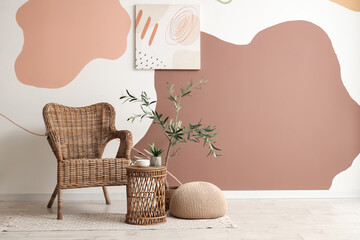 Stylish coffee table with houseplant, armchair and painting near color wall