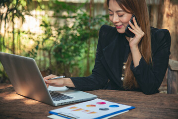 Happiness Asian Woman working from home using laptop online meeting in home office. Happy relax...