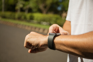 Individual interacting with smartwatch on wrist while outdoors