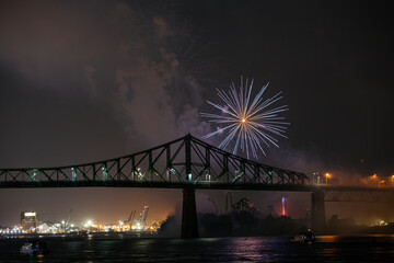 Fototapeta premium Drone flight through holiday fireworks above water with reflection on the black sky background