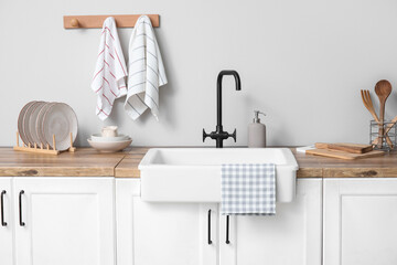 Counter with sink, utensils and clean towels in kitchen