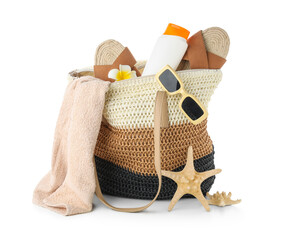 Wicker bag with bottle of sunscreen cream and beach accessories isolated on white background,...