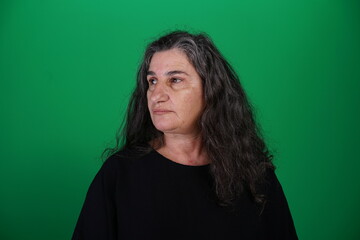 Obraz premium Unedited Portrait of Woman’s Face Expressing Various Emotions – Green Studio Background