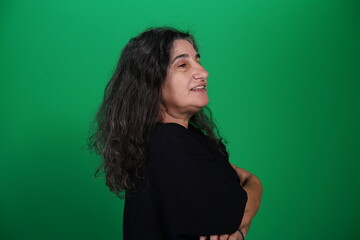Fototapeta premium Woman with a variety of emotions, wearing a black t-shirt ,standing against a green background. Studio shot with copy space. Not edited image