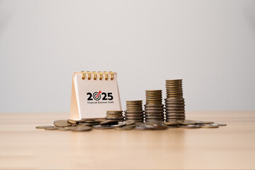 Stacked coins with 2025 financial business goals calendar and upward arrow graph, representing investment planning, saving money, business growth, economic strategy, and financial success in 2025