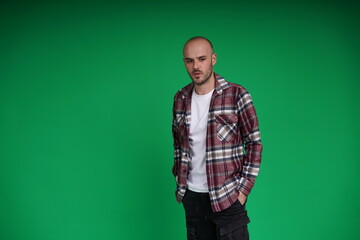Young man with a variety of emotions, standing against a green background. Studio shot with copy space.