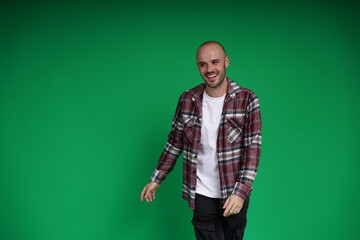 Young man with a variety of emotions, standing against a green background. Studio shot with copy space.