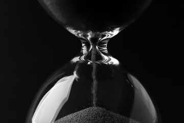 Crystal hourglass on black background, closeup