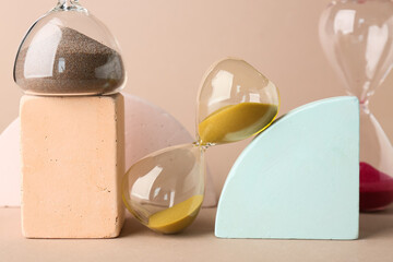 Hourglasses and podiums on beige background