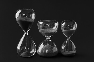 Crystal hourglasses on black background