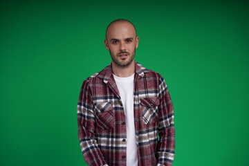 Fototapeta premium Young man with a variety of emotions, wearing a white t-shirt standing against a green background. Studio shot with copy space.