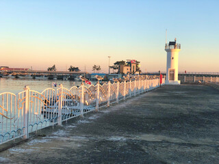 Sunrise Light on Seaside Pier and Lighthouse