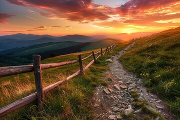 Scenic mountain path with a wooden fence under a vibrant sunset sky